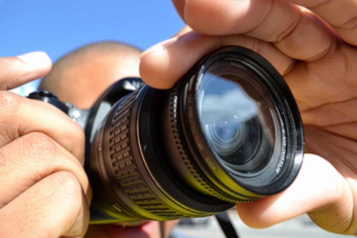 A digital SLR camera being held by a photographer.
