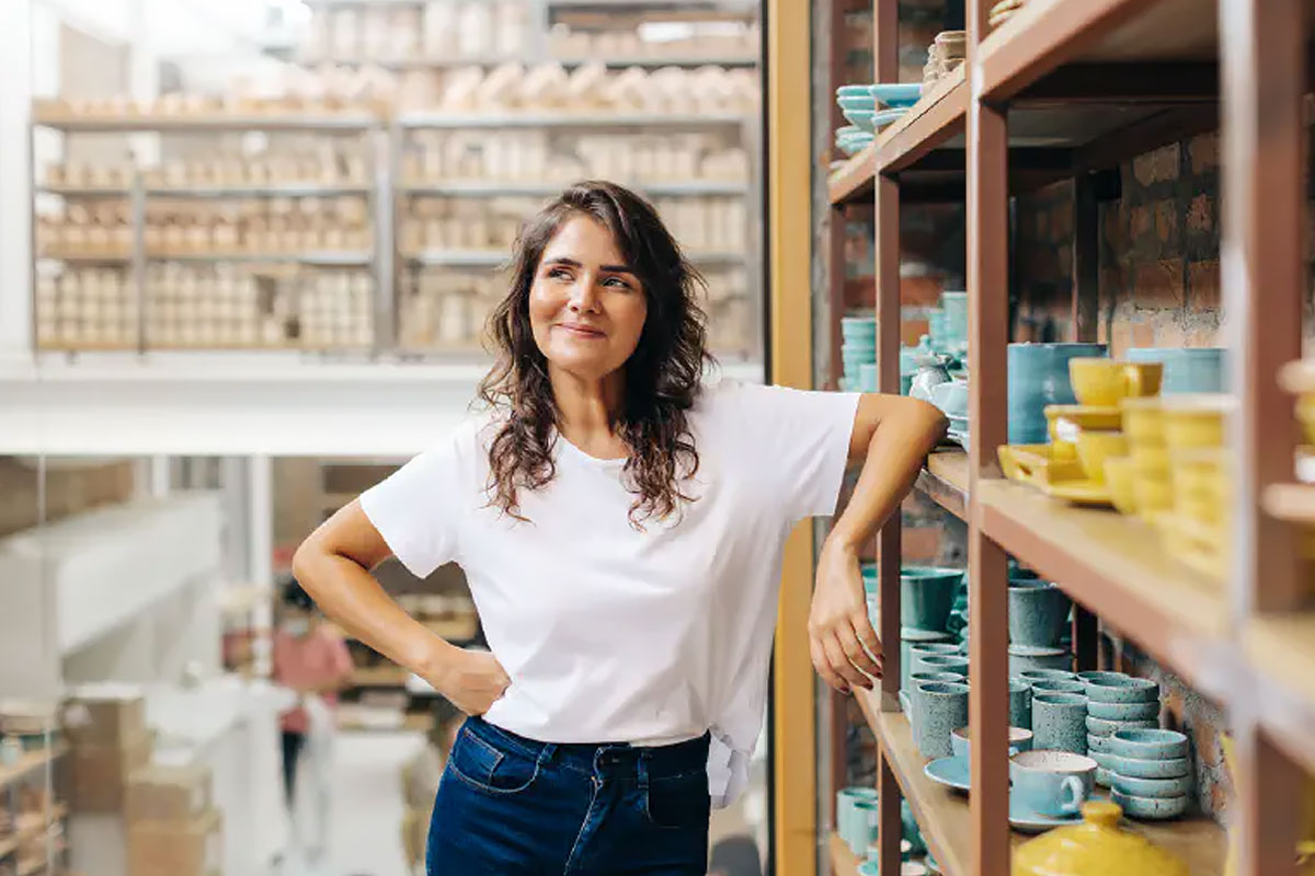  A happy entrepreneur managing a shop with handmade ceramic products. 