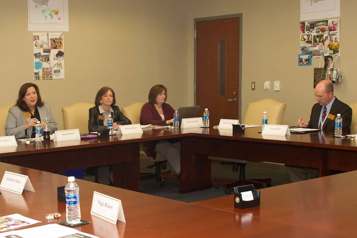 A meeting of at least four people who are reviewing materials and preparing for their upcoming experiences.