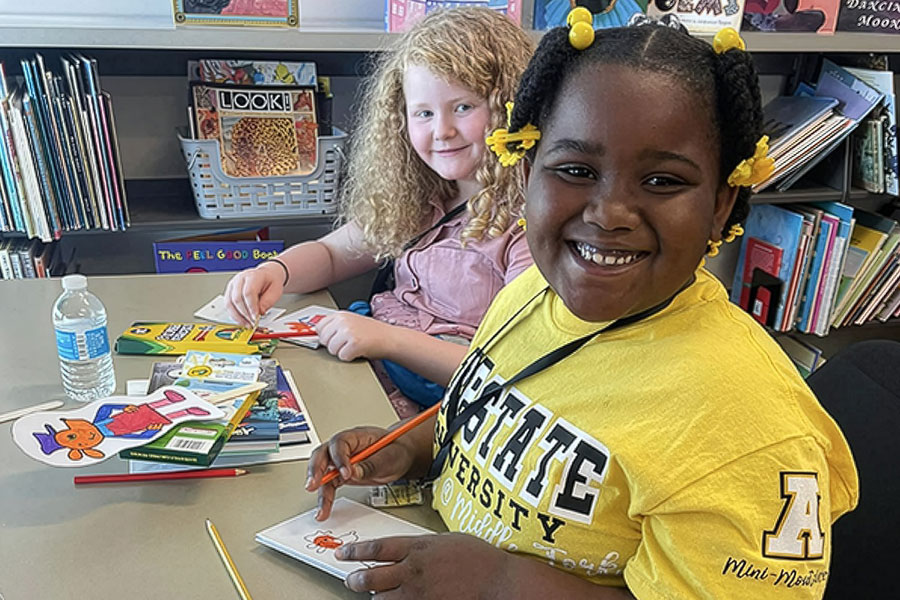 Two children participating in educational activities within a classroom setting.