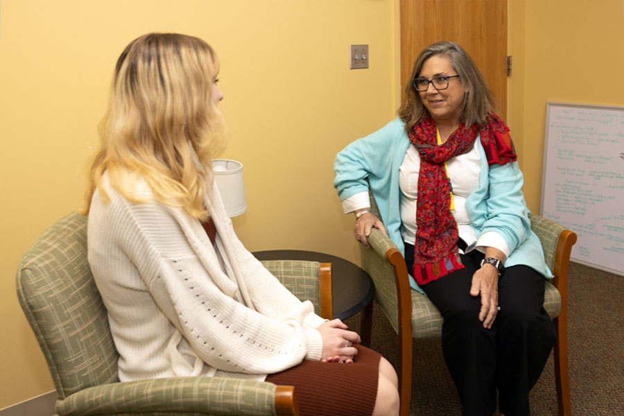 Seated one-on-one advising session between student and professional in a quiet office space.
