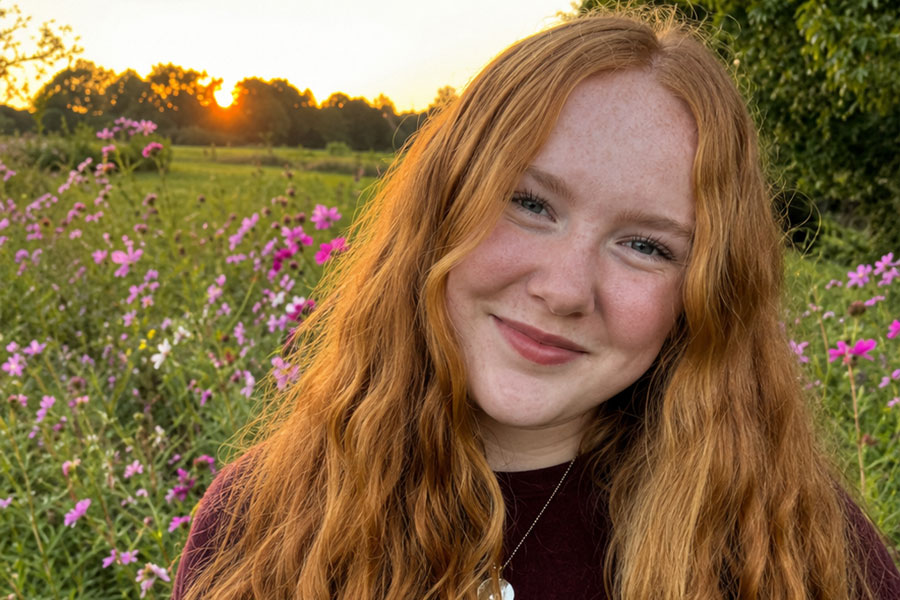 App State Teaching Fellow, Thea Dowdle in a field at sunset. 