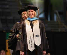 Doctoral student being hooded at commencement.