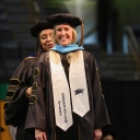 Doctoral student being hooded at commencement.