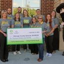 Extra Yard for Teachers Holding check