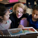 Chancellor Sheri Everts reads to Academy third-graders Larise Serrano Hernandez (left) and Yarel Candela-Lucero on Thursday. 