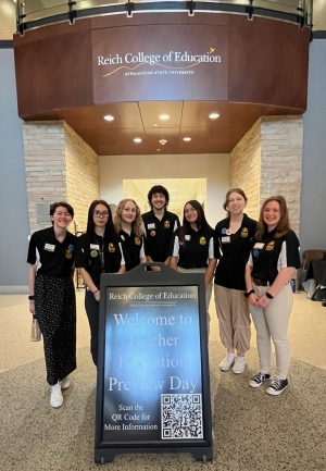 Education Peer Ambassadors standing around a sign