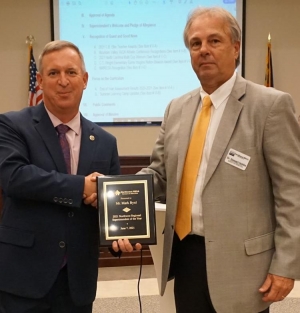 Wilkes School Superintendent Mark Byrd, left, is presented a plaque for being named School Superintendent of the Year by superintendents of school districts in the Northwest Regional Educational Service Alliance (NWRESA). Presenting the plaque is Dr. Stewart Hobbs, NWRESA executive director.  Photo courtesy of Morgan Mathis/Wilkes County Schools