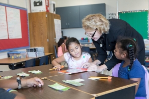 At the Appalachian State University Academy at Middle Fork, Appalachian Chancellor Sheri Everts prepares to read a story with students in the third grade classroom of teacher Heather Wham. Students photographed are: Clarise Serrano-Hernandez and Yarel Candela-Lucero. Photo by Marie Freeman