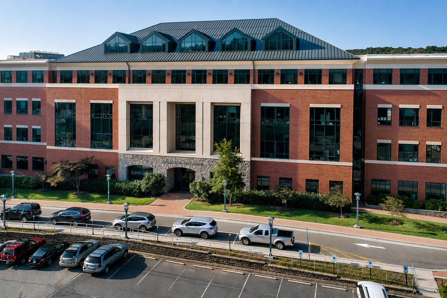 RCOE building with cars parked out front on a sunny day. 