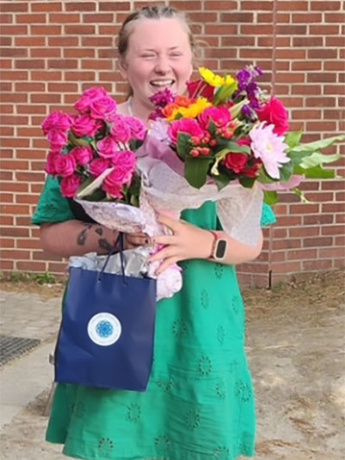 Kristy Cook celebrating with flowers for being named Early Educator of the Year in Watauga County.