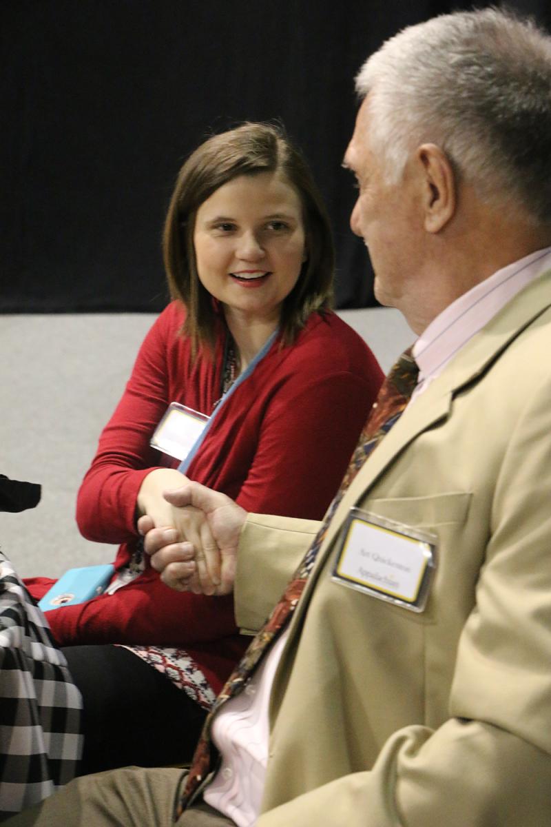 Dr. Art Quickenton greets students at his table.