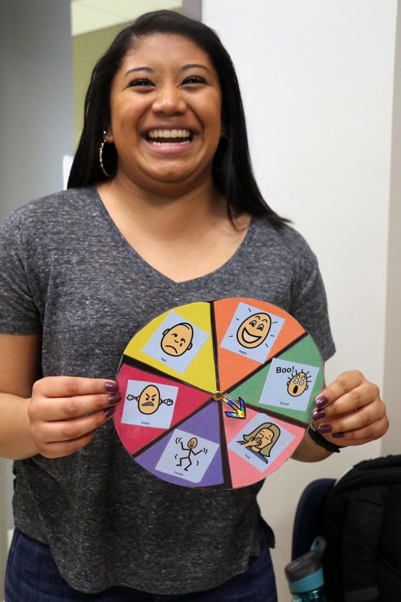 Micah M. demonstrates her Wheel of Emotions which allows students to spin the wheel to discuss the corresponding emotion.