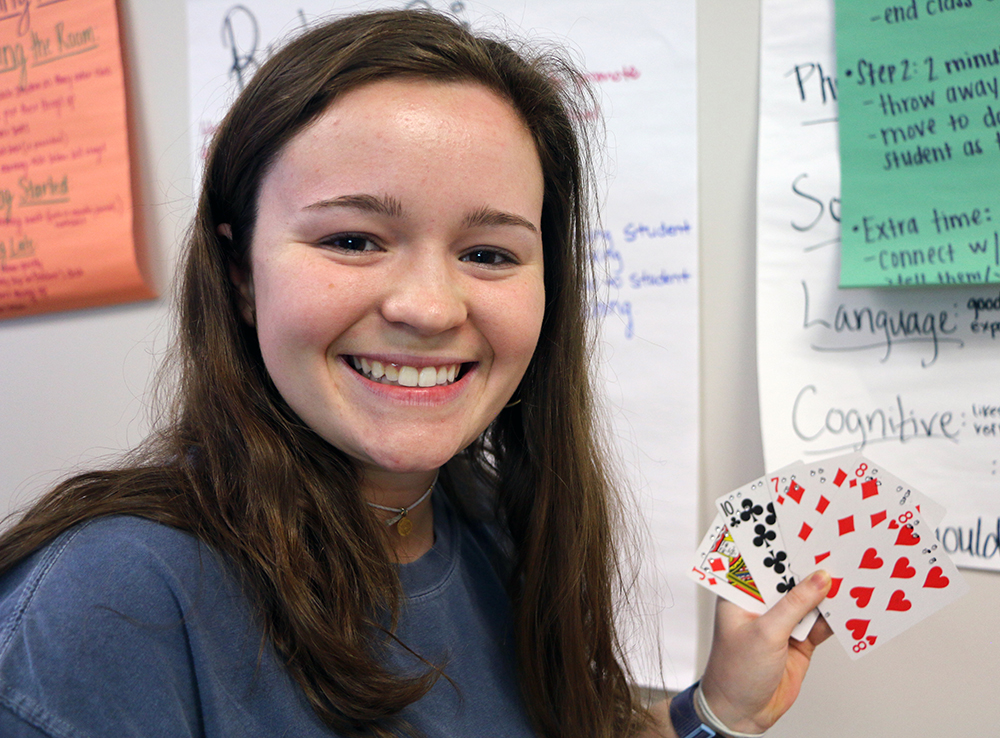 Merritt R. displays the Braille Playing Cards she created for players with visual impairments.