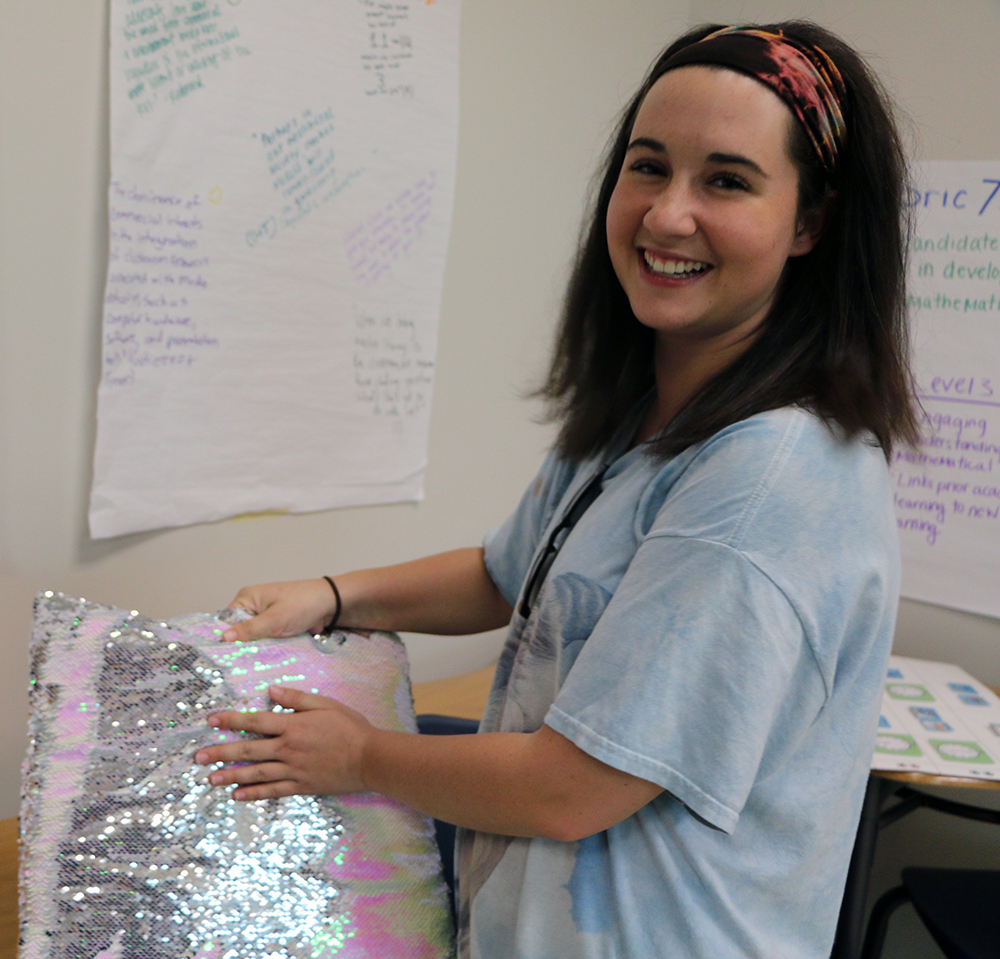 Amanda S. demonstrates the interactive texture of her Weighted Pillow for students with autism.