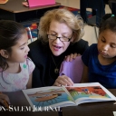 Chancellor Sheri Everts reads to Academy third-graders Larise Serrano Hernandez (left) and Yarel Candela-Lucero on Thursday.