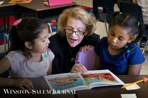 Chancellor Sheri Everts reads to Academy third-graders Larise Serrano Hernandez (left) and Yarel Candela-Lucero on Thursday.